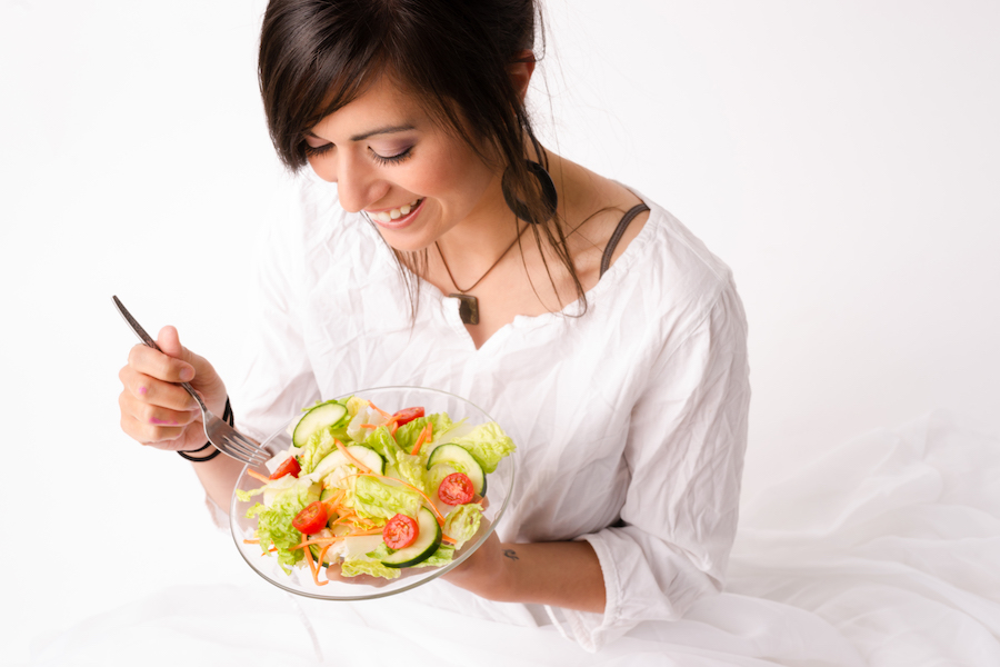 kvinne spiser salat, hvit bakgrunn